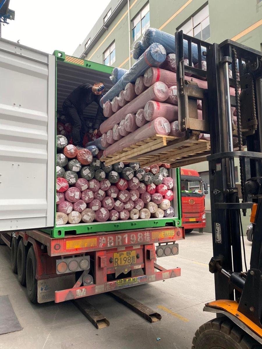 Chargement d’un conteneur de rouleaux de tissus dans notre réseau textile en Chine
